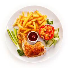 Grilled chicken legs with chips and vegetables 