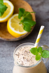 Banana and lemon smoothie, on the grey  background.