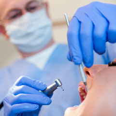 Dentist using dental drill. Focus on hands