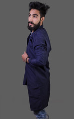 Studio shot of Iraq brunette boy isolated on gray background with epic beard