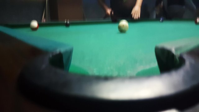 Sinking the ball number 10 with a soft shot in to billiard pocket in an eight ball game