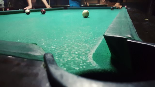 Sinking the ball number 4  with a spider rest head in to billiard pocket in an eight ball game
