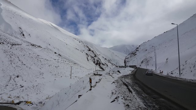 CHALUS, IRAN, DEC 2015: A right to left pan of cars in the famous mountain road Chalus during winter - the foggy and snowy mountain.