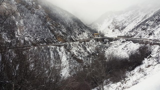 CHALUS, IRAN, DEC 2015: A left to right pan of cars in the famous mountain road Chalus during winter - the foggy and snowy mountain.