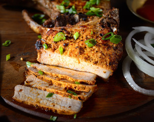 raw pork steak on a wooden surface with spices