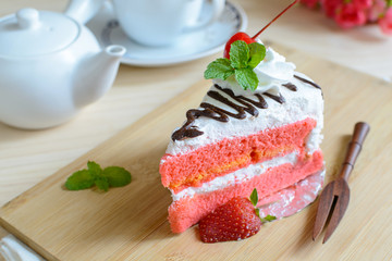 strawberry cake with tea on wooden plate
