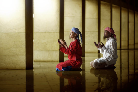 Two religious muslim man praying together