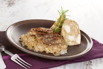 Baked pork chop with dumplings and sauerkraut.