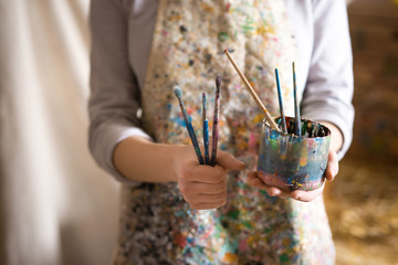 Closeup of female artist hand holding paintbrush - 103906534