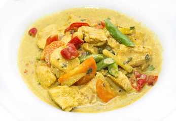 chicken curry with vegetables on a white plate in a restaurant