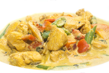 chicken curry with vegetables on a white plate in a restaurant