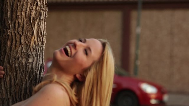 A gorgeous model posing by a tree 