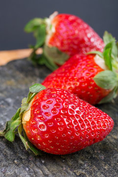 large strawberries dark background. choicest berries. color image with space for text. side and top view