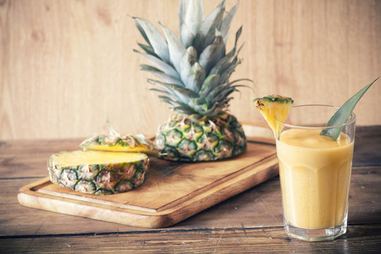 pineapple smoothie on wooden table.