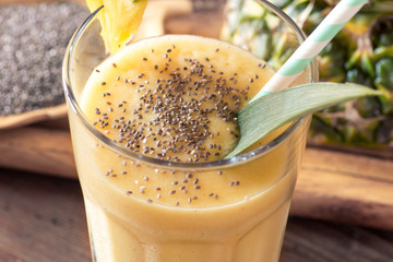 pineapple smoothie with chia seed on wooden table.