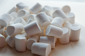 Fototapeta na wymiar beautiful little marshmallows scattered on a light background
