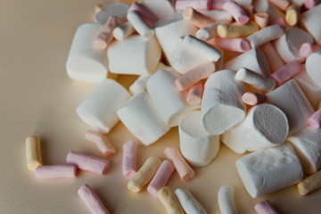 beautiful little marshmallows scattered on a light background