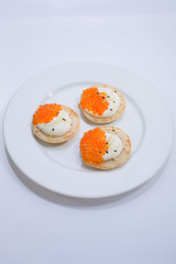 appetizer of caviar red in small pancakes with cream. homemade gourmet food. European cuisine