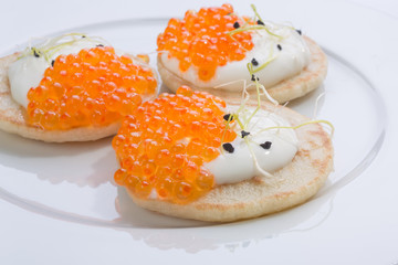 appetizer of caviar red in small pancakes with cream. homemade gourmet food. European cuisine