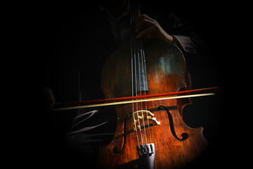 Man playing on cello on dark background