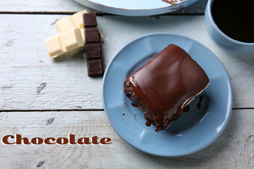 Delicious chocolate brownie on plate on wooden background