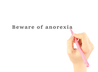 Human hand writing text Beware of Anorexia on transparent whiteboard