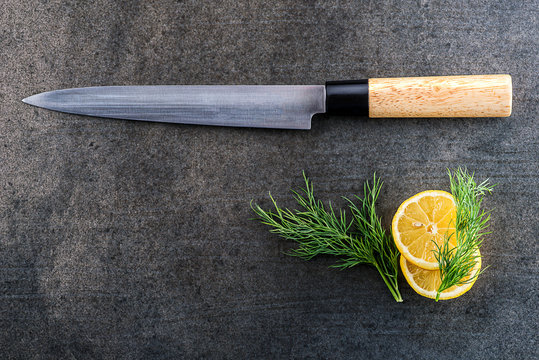 japanese fillet fish knife with lemon on grey background, kitchen accessories