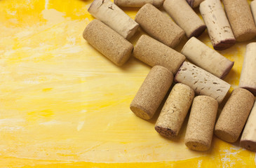 Heap of wine corks on yellow background texture