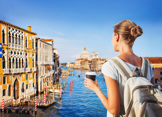 Fototapeta na wymiar Back side of traveler girl looking at the Grand canal in Venice, Italy, travel concept