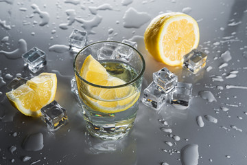 Fototapeta na wymiar Yellow lemons in water glass
