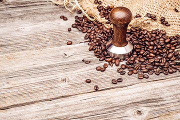 professional wooden coffee stamper with coffee beans and sack on wooden background, product photography for coffee shop