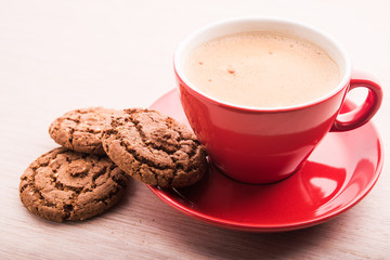 Coffee cup with chocolate cookies on kitchen table