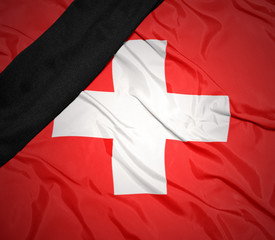 national flag of switzerland with black mourning ribbon