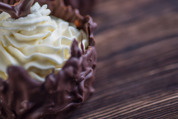 sweet chocolate dessert with vanilla cream and chocolate hearts on wooden background, product photography for patisserie or restaurant
