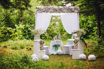 Wedding arch with table and chairs decorated with flowers