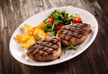 Grilled beefsteaks and vegetables