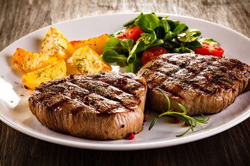 Grilled beefsteaks and vegetables