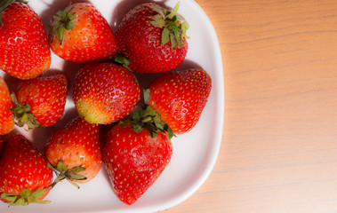 Strawberries in dish on wooden table with soft-clarity