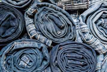 background of a stack rolled jeans close up
