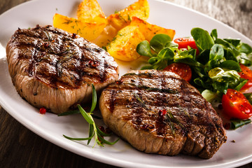Grilled beefsteaks and vegetables