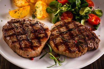Grilled beefsteaks and vegetables