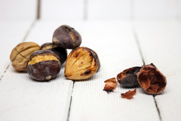 hot toasted chestnuts on white wooden background