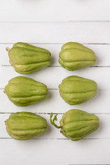 Chayote fruit on white wood background