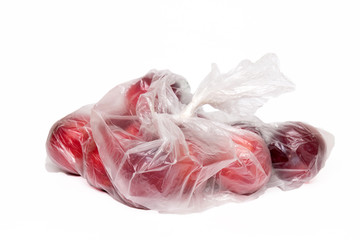 View of some plums inside a plastic bag.