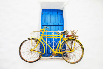 Fototapeta na wymiar Old bicycle with a basket leaning against a wall in Greece