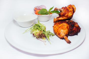Fried chicken legs with salad from vegetables and greens with white sauce