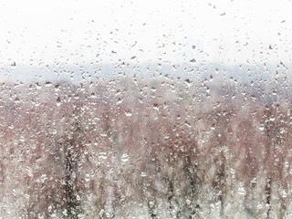 water drops from melting snow on home windowpane