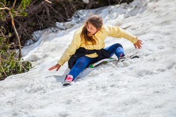 Fototapeta na wymiar girl is sliding from a snowy mountain
