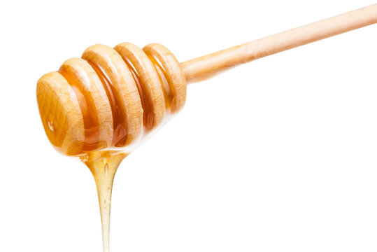 clear honey flows down from wooden stick isolated