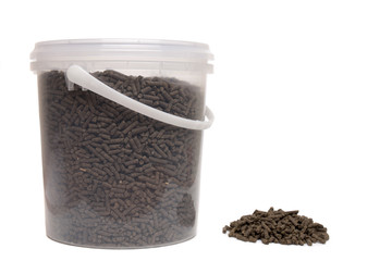 Bucket of compressed organic fertilizer.